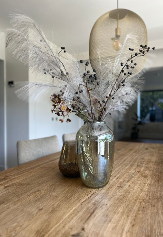 Eikenhouten eettafel glazen vazen met siertakken