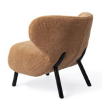 Zwart metalen poten onder bruin fauteuil polyester