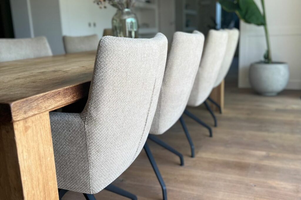 Beige eetkamerstoelen met zwarte poot aan houten tafel