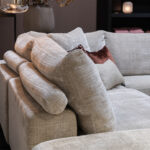 Rolletjes achter rugkussen beige stoffen bank