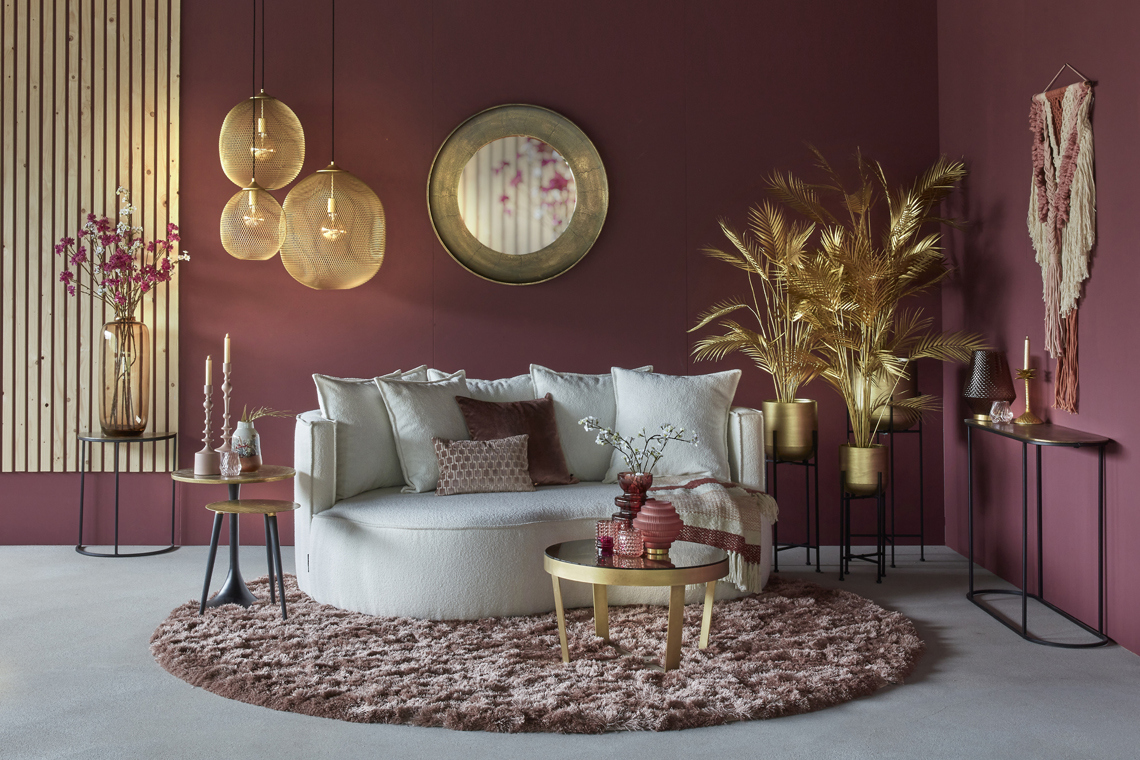 Ronde bank beige woonkamer met roze en gouden accessoires