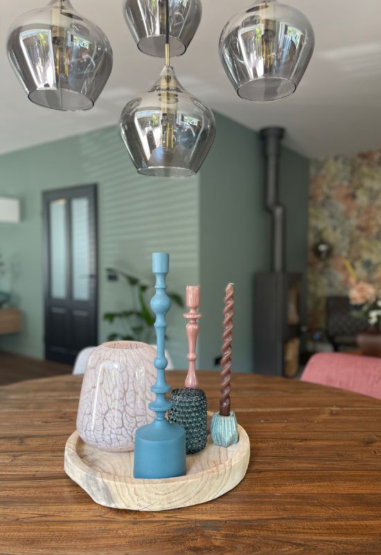 Houten schaal met blauwgrijze en roze kandelaars en waxinelichthouders glazen hanglamp