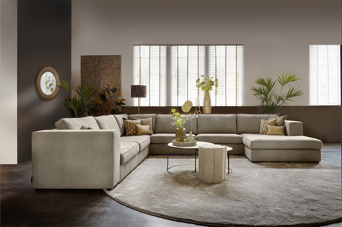 nieuwbouwhuis inrichting beige hoekbank rond vloerkleed veel woonaccessoires