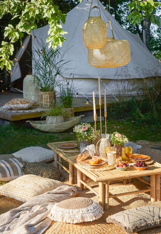 Buiten picknick met lage tafeltjes en kussentjes op de grond