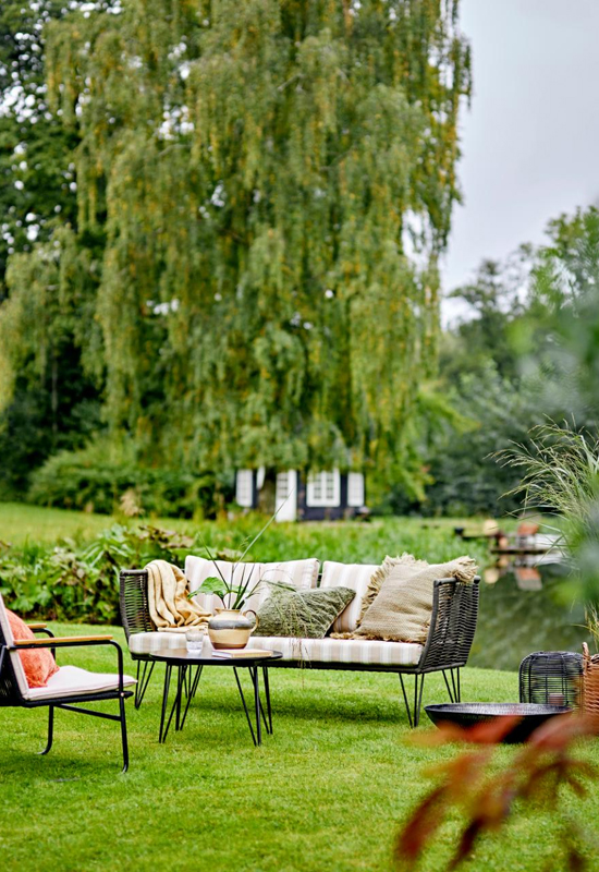 Tuinbank en tafeltje kussens in het gras