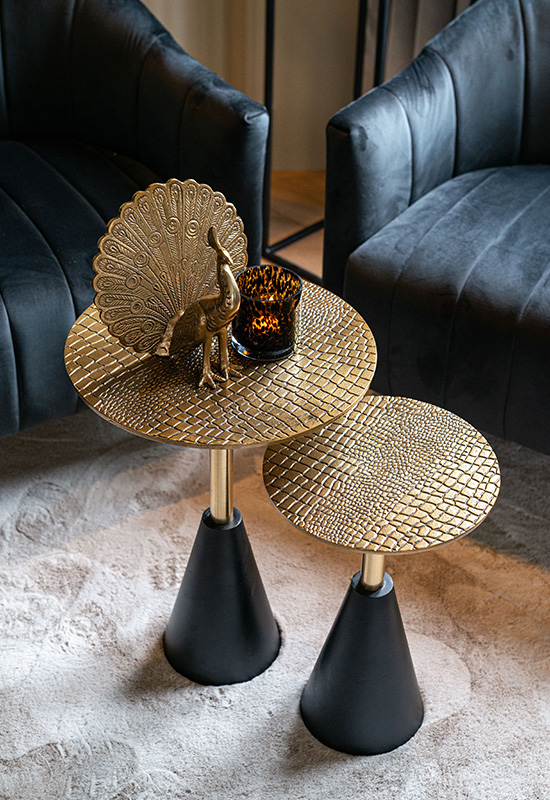 Zwarte fluwelen fauteuils gouden salontafels rond met krokodillen textuur gouden pauw ornament