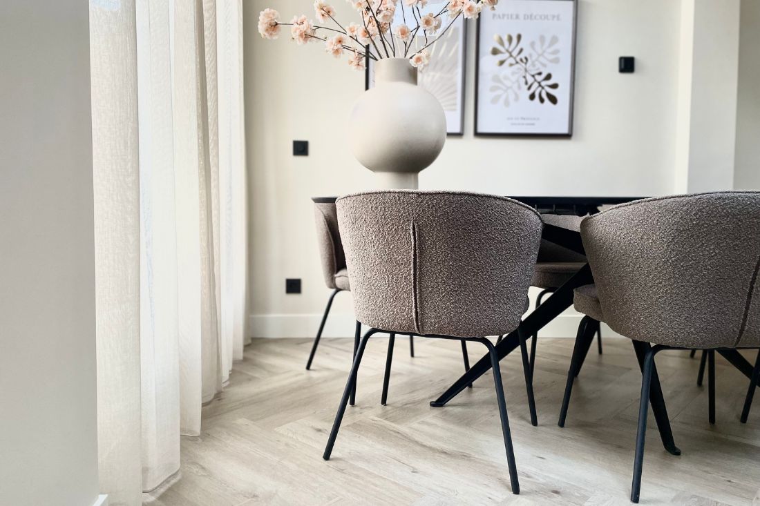 Bruine bouclé eetkamerstoelen beige bolvaas houten visgraat vloer