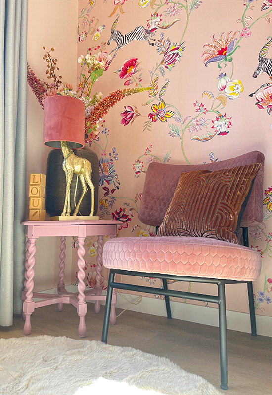 Roze fauteuil gouden giraf lamp met roze kap wit rond hoogpolig vloerkleed roze claudi sierkussen