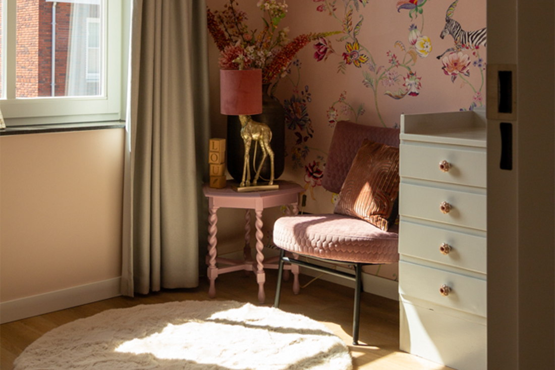 Roze meisjes kinderkamer wit zacht vloerkleed roze behang met bloemen roze fauteuil