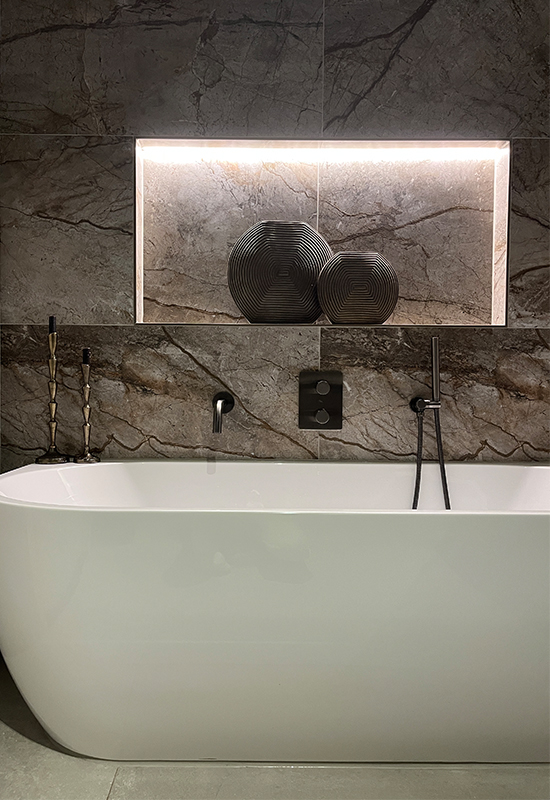 donkergrijze badkamer marmeren tegels zwarte kranen bronzen vazen in nis