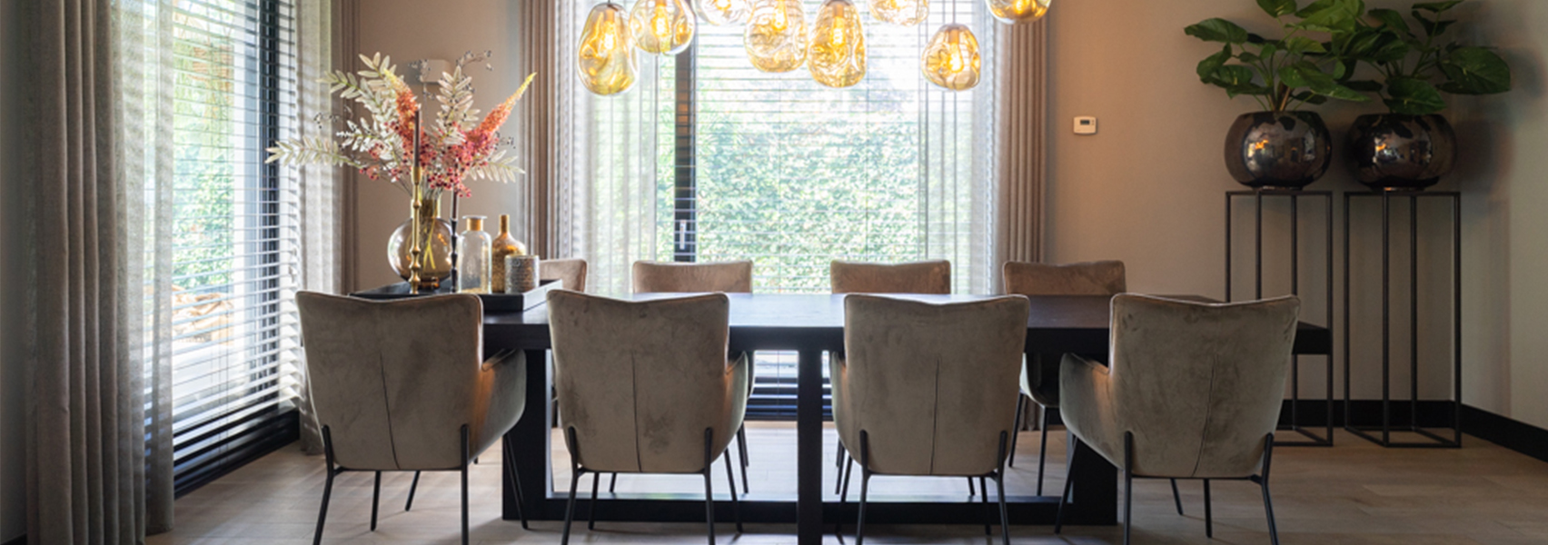 Lange zwarte eettafel met acht beige eetkamerstoelen hanglamp met acht lichtbronnen