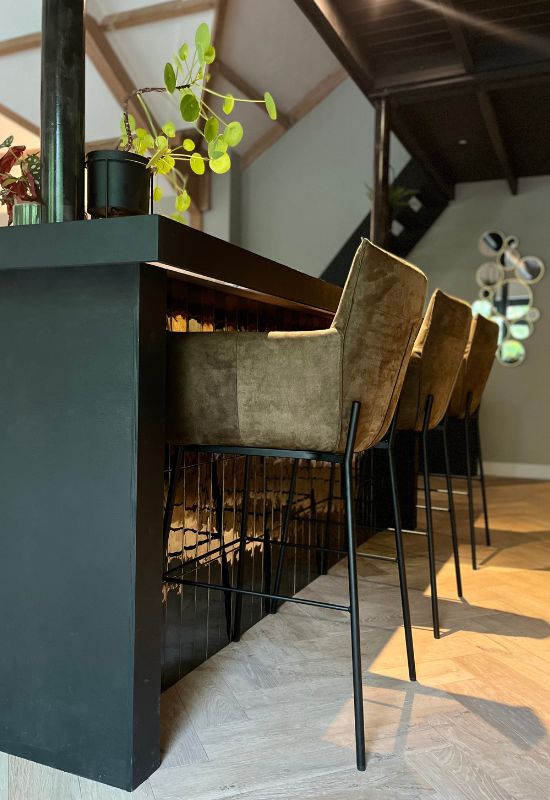 Zwart betegelde bar met suede barstoelen in olijf groen