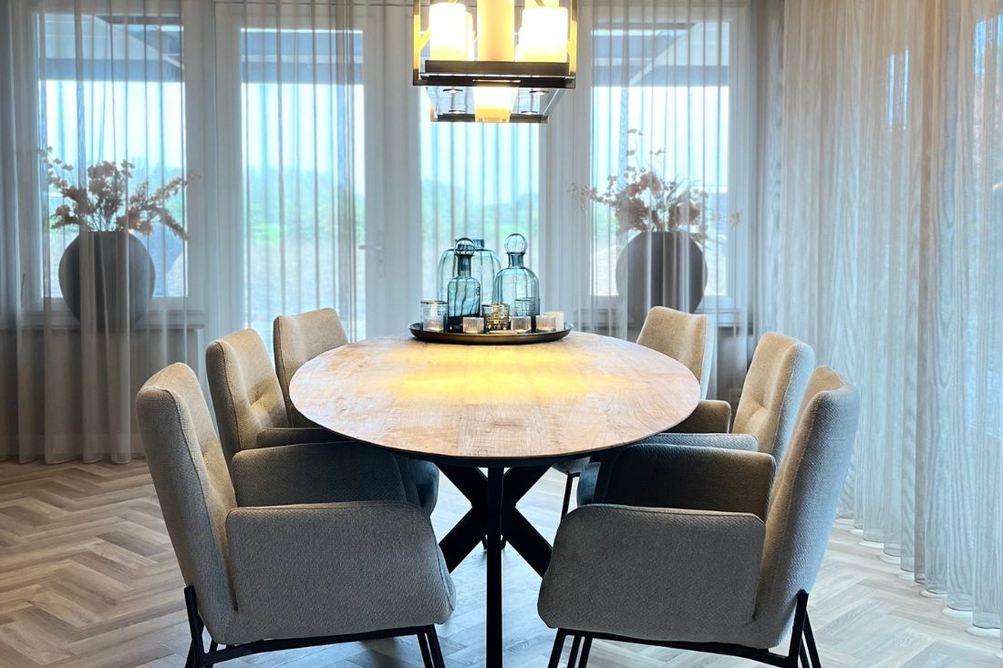 ovale eetkamertafel met zes grijze eetkamerstoelen met armleuning