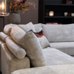 Rolletjes achter rugkussen stoffen hoekbank beige