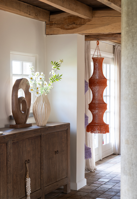Hout dressoir met beige vaas en hout ornament schelpenketting