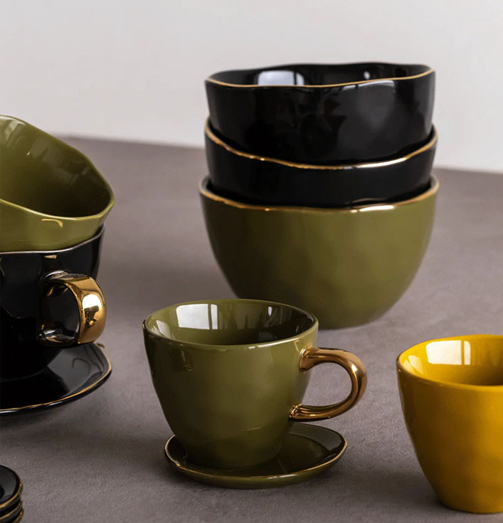 zwarte en groene schaaltjes en koffie kopjes met gouden details