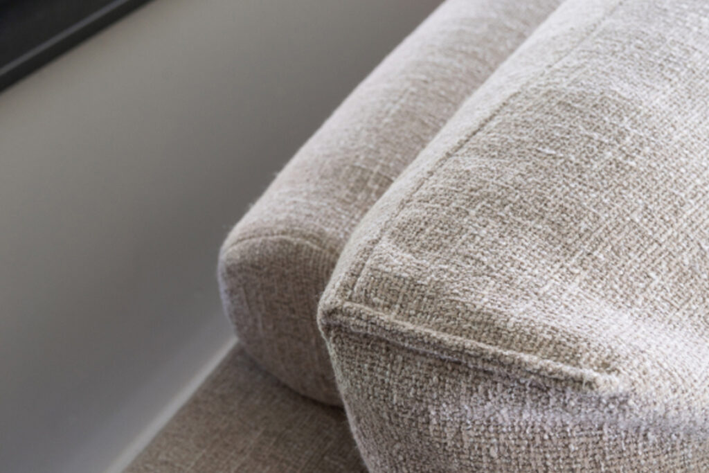 Rolletjes achter rugkussens grijs beige bank