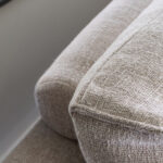 Rolletjes achter rugkussens grijs beige bank