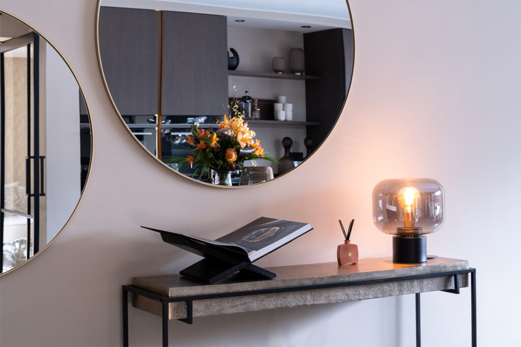 Gezellig hoekje met gedecoreerde sidetable en twee ronde spiegels