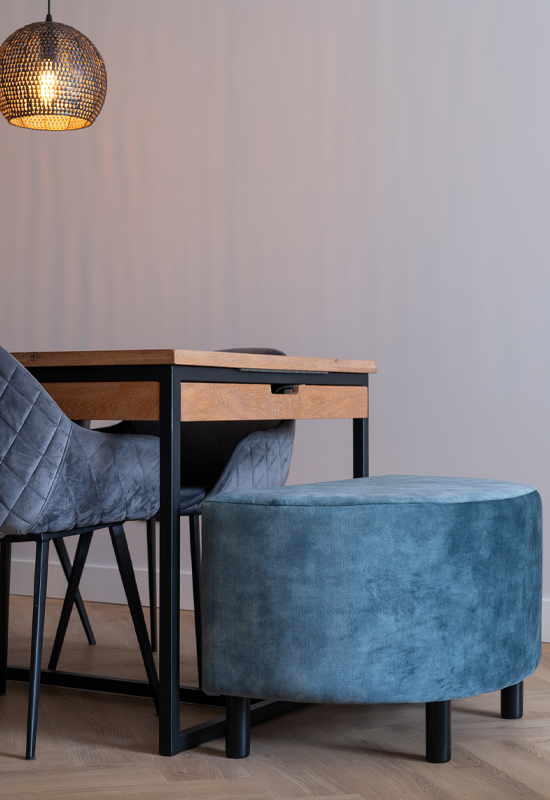 Blauwe eetkamerstoelen en hocker aan houten eettafel