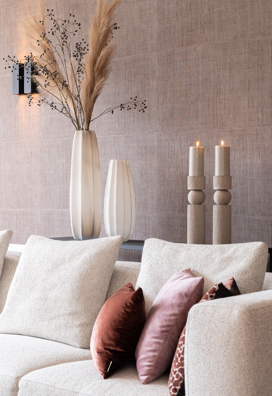 Grijs beige hoekbank met sidetable en accessoires achter de bank voor gezelligheid