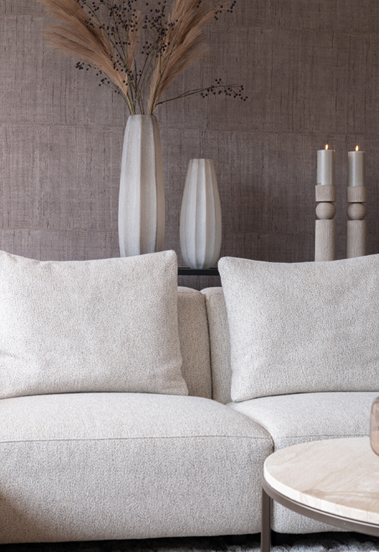 Grijs beige hoekbank met sidetable en accessoires achter de bank voor gezelligheid