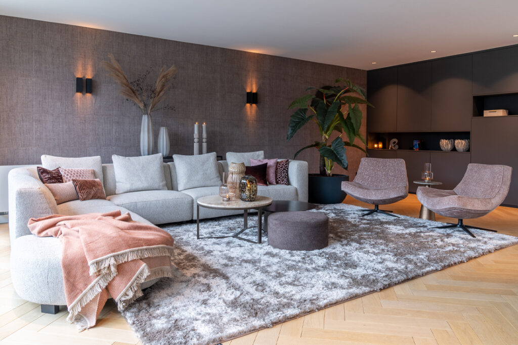 Interieur modern met roze sierkussens hoekbank rond element