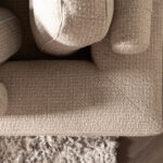 Beige stoffen hoekbank rolletjes rugkussen