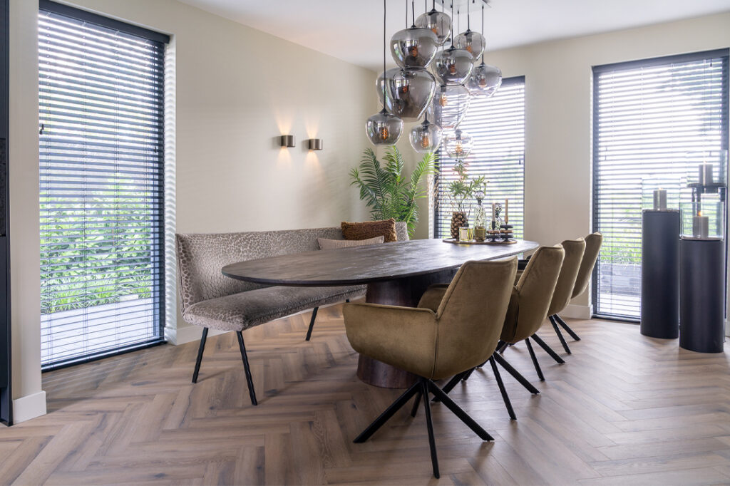 Eethoek bruin houten tafel okergele stoelen en eetkamerbak