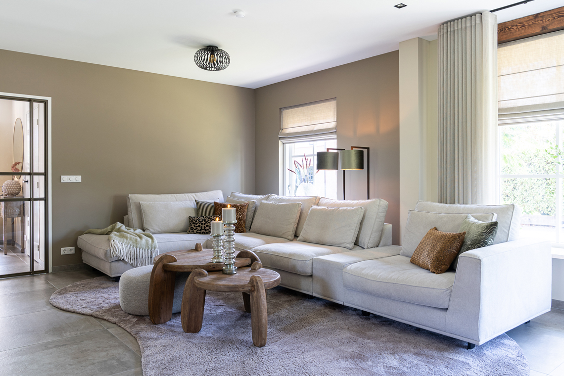 Woonkamer hoekbank beige met houten salontafels