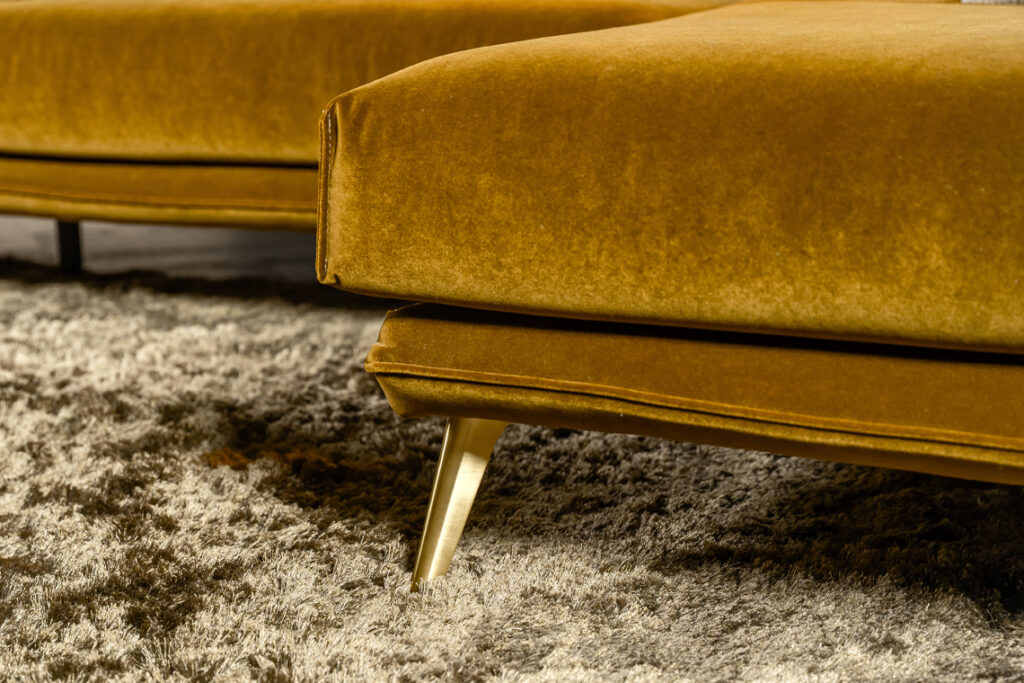Gouden metalen poot onder hoekbank stof okergeel goud