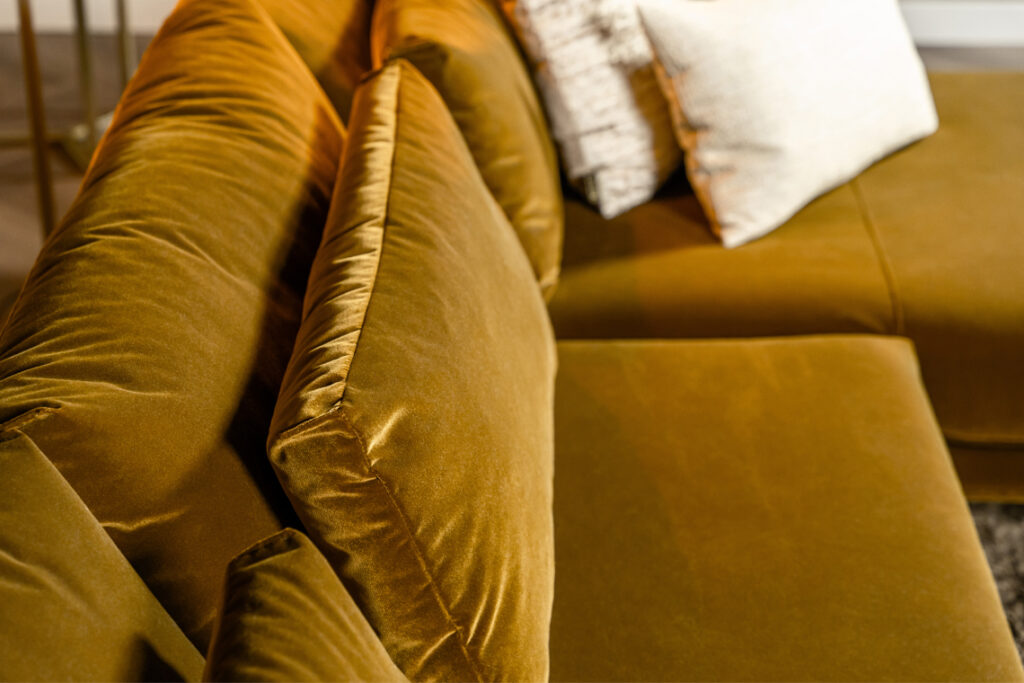 Hoekbank stof velvet okergeel lendenkussens