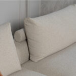 Beige stoffen hoekbank met rolletjes