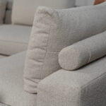 Rolletjes achter rugkussen beige stof hoekbank